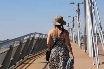 A woman with a hat. A pier on the Vistula river in Płock, Poland - obrazy, fototapety, plakaty