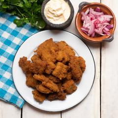 Fish chicharron with mayonnaise and onion on white background