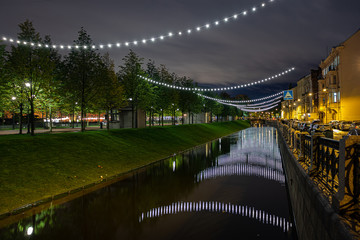 Obraz premium Garland over the river in the park