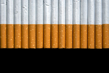 top view of  cigarettes in a row, on a black table