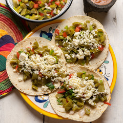 Mexican nopal cactus tacos with cheese on white background © Guajillo studio