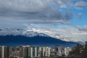 Amazing cloudy sky over Santiago skyline and the snowed Los Andes mountains, Chile