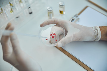 Biochemist adding a liquid solution to a test specimen