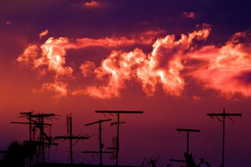 Antenas no telhado e o céu avermelhado