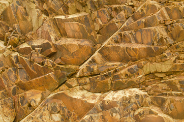 rough background texture of the natural stone is a pattern of brown stone lined vertically.
