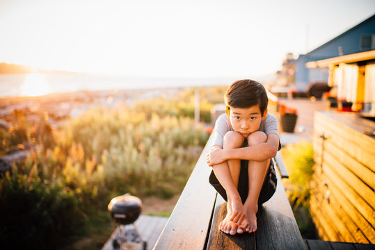 Portrait of boy by the sea at sunset
