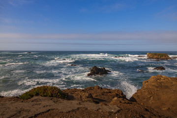 Fototapeta na wymiar Waves breaking on large rocks in ocean