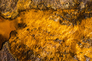Top view shot of water flowing over the rock in a river bed in Rio Tinto mining park
