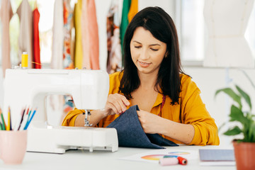 Seamstress working at her workplace. Latin woman owner of small business.