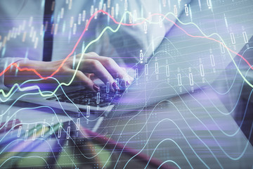 Double exposure of woman hands typing on computer and financial graph hologram drawing. Stock market analysis concept.