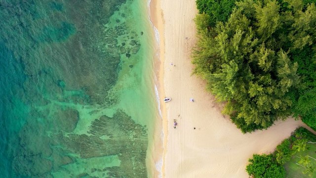 The aerian view of a beach of Hawaii with a white boat © Shenzen Photo Lab