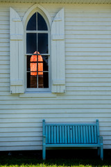 old church wooden window and bench with shutters with other window in background