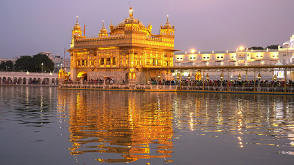 golden temple with pink sunset sky in amritsar