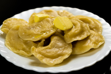 White plate with dumplings and pieces of melting butter
