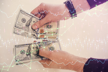 Multi exposure of financial graph drawing hologram and USA dollars bills and man hands. Analysis concept.