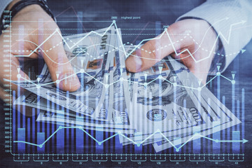 Multi exposure of financial graph drawing hologram and USA dollars bills and man hands. Analysis concept.