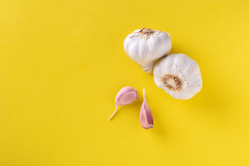 Top view of garlic cloves on a yellow background