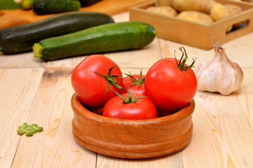 bowl with tomatoes and assorted fresh vegetables on the kitchen table