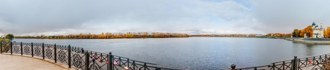 Fototapeta na wymiar Beautiful lake and yellow trees in autumn cloudy day. Panoramic landscape.