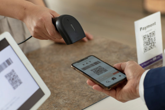 キャッシュレス決済のスマートフォンとバーコードリーダー