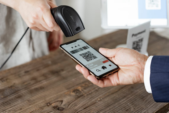 キャッシュレス決済のスマートフォンとバーコードリーダー