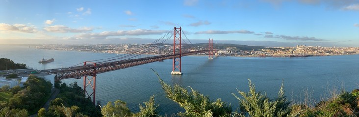 A statue of Cristo Rey and a view of the bridge named April 25 in Lisbon, Portugal.