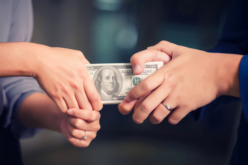 Hands pulling at stack of bank notes