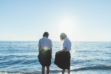 夕暮れの海にいる女子高生
