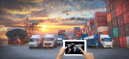 Hand holding tablet is pressing button on touch screen interface in front Logistics Industrial...