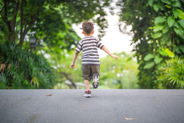 little boy running on a road