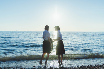 夕暮れの海にいる女子高生