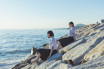 Fototapeta premium 夕暮れの海にいる女子高生