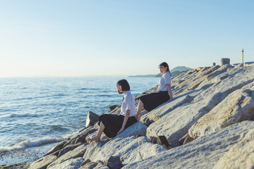 夕暮れの海にいる女子高生