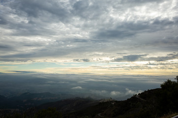On top of a mountain with clouds across the sky