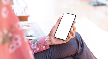 cell phone mockup image blank white screen.woman hand holding texting using mobile on desk at coffee shop.background empty space for advertise.work people contact marketing business,technology
