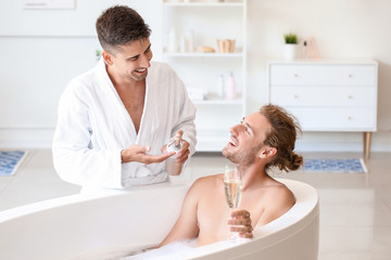 Happy gay couple spending time in bathroom