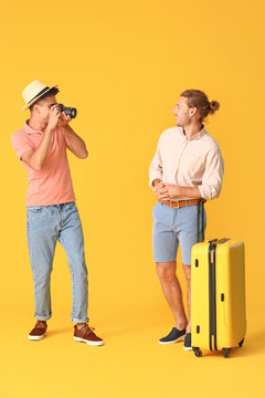 Couple of gay tourists on color background