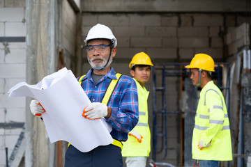 Architect and construction workers working with blue print at construction site,Construction concept.
