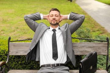 Handsome businessman relaxing in park