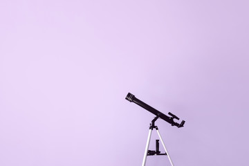 Modern telescope on color background