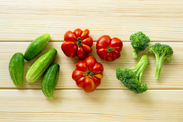 Set of vegetables. Tomatoes, cucumbers and broccoli on a light wooden background