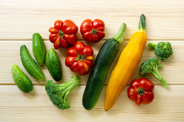 Set of various summer vegetables on a light wooden background, top view