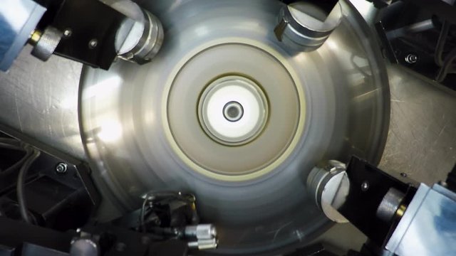 Top view of an automatic  bruting machine used in diamond industry, operated by an African woman with a loupe