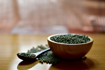 Closeup of Fresh Mung Beans in a wooden bowl and wooden spoon isolated on the white background, Full depth of field.