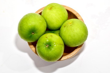 Closeup of Fresh Green jujube in a wooden bowl isolated on white background, Selective Focus.