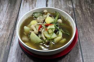 Traditional spicy soup of mixed fresh mushroom, chopped sweet potato, chilly and local herbal vegetable in the bowl. Famous hot and spicy ancient vegetarian menu in Thai restaurant.