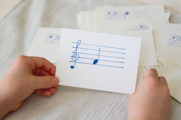 Young child practices naming music notes with flash cards; Young child memorizes musical notes