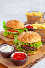 American beef burger with french fries, bun, beef cutlet, cheese