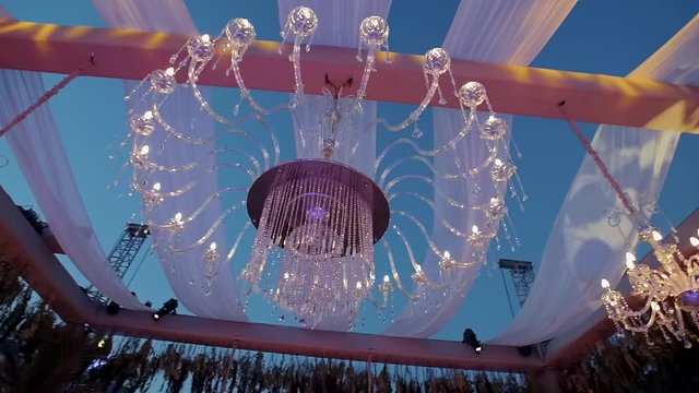 Chandelier details in outdoor organization. There are tulles and flowers around
