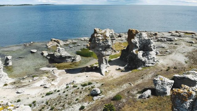 Flying over tall limestone sea stacks or rauks, Gotland Island, Sweden